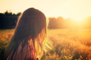 woman standing in field golden hour