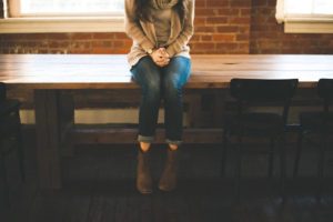 shoes hanging over edge woman clutching hands