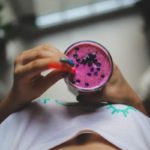woman sipping colorful smoothie